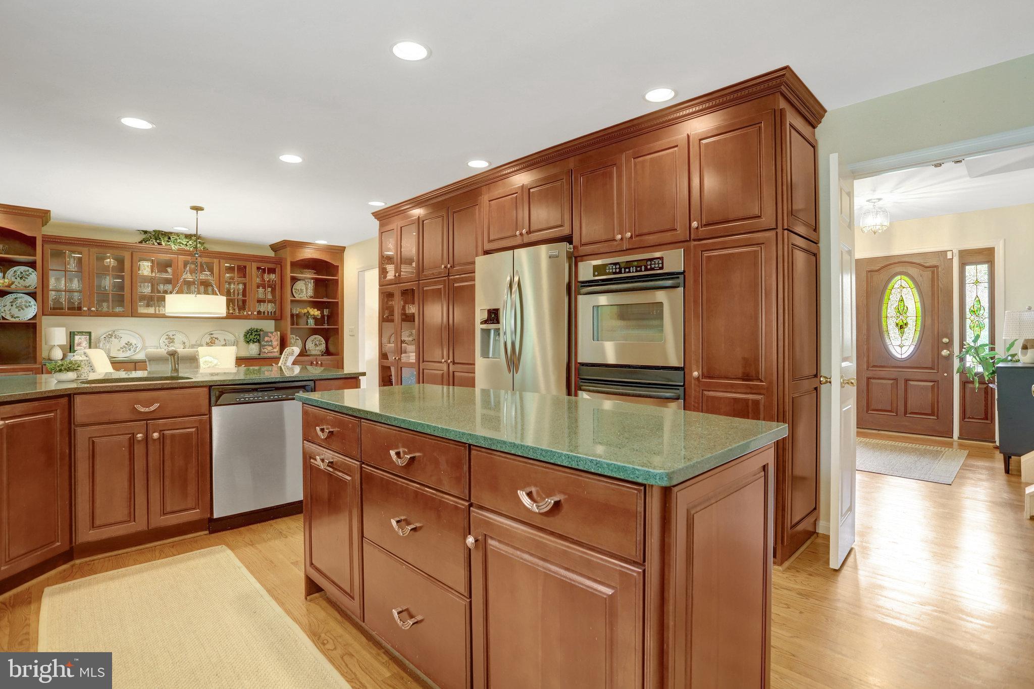 7006 Maple Tree Lane Springfield, VA 22152 - Photo 5 of 49 a kitchen with stainless steel appliances granite countertop a refrigerator and wooden cabinets