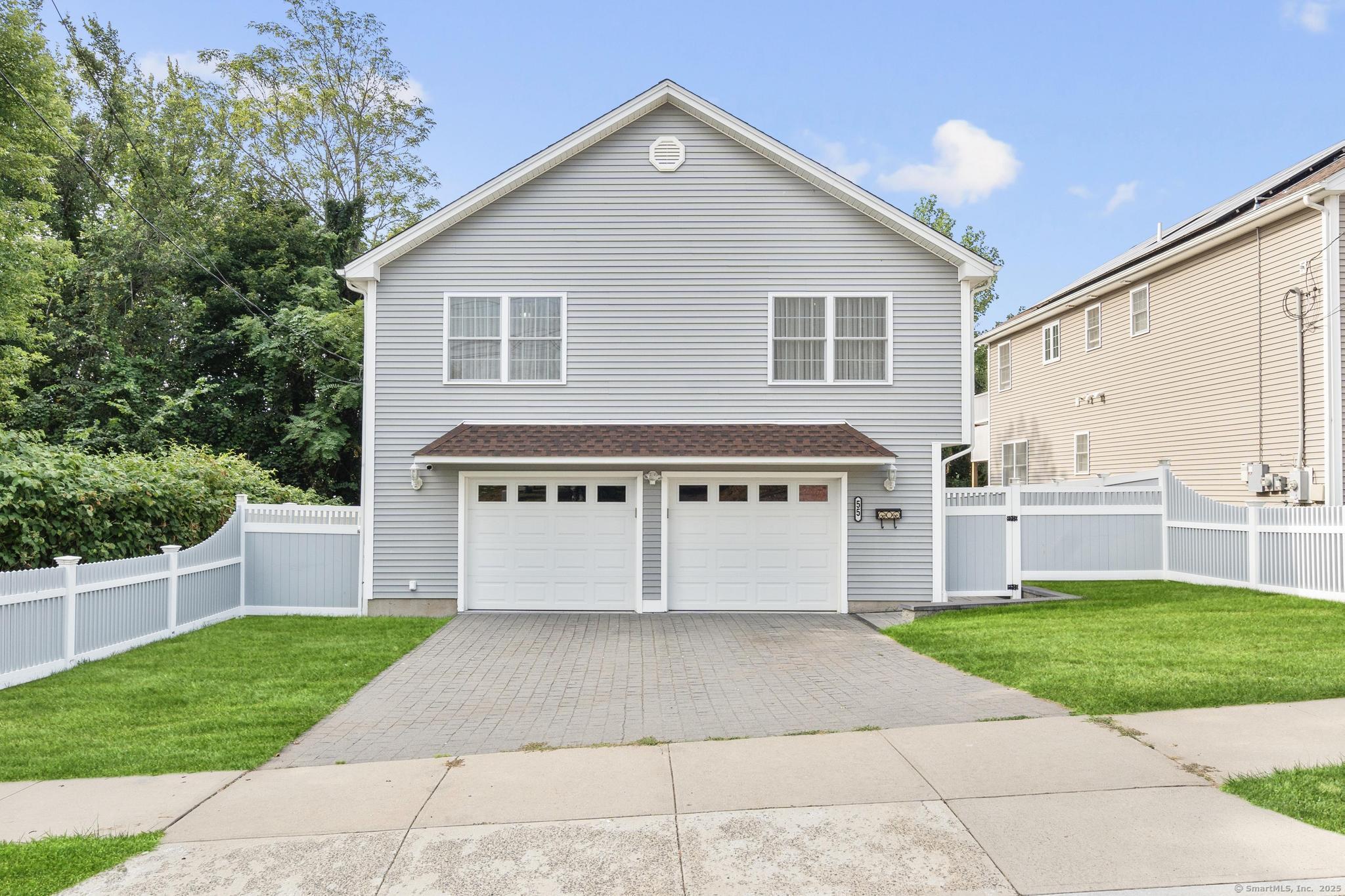 a view of a house with a yard and a garage