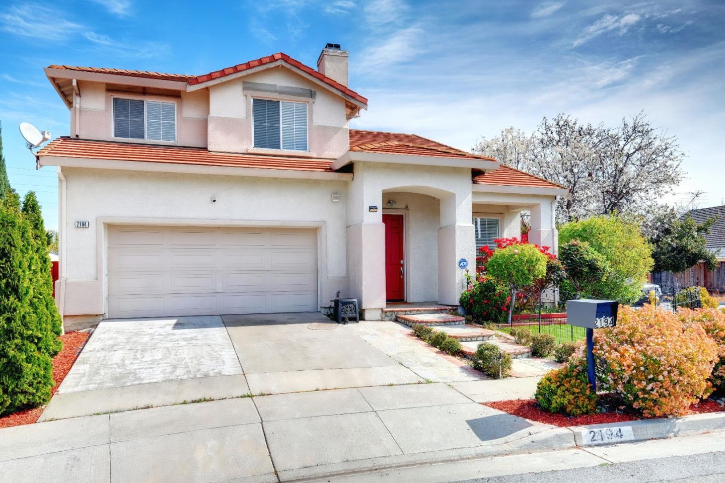 a front view of a house with a yard and potted plants