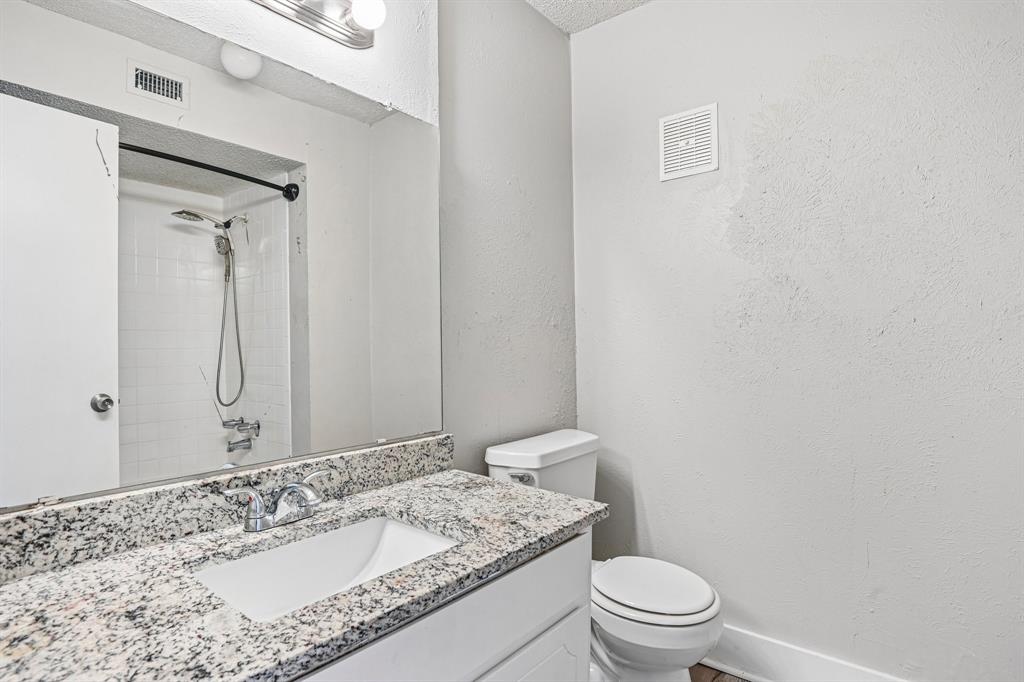 5534 Boca Raton Boulevard, Unit 292 Fort Worth, TX 76112 - Photo 26 of 31 a bathroom with a granite countertop sink a toilet and a mirror