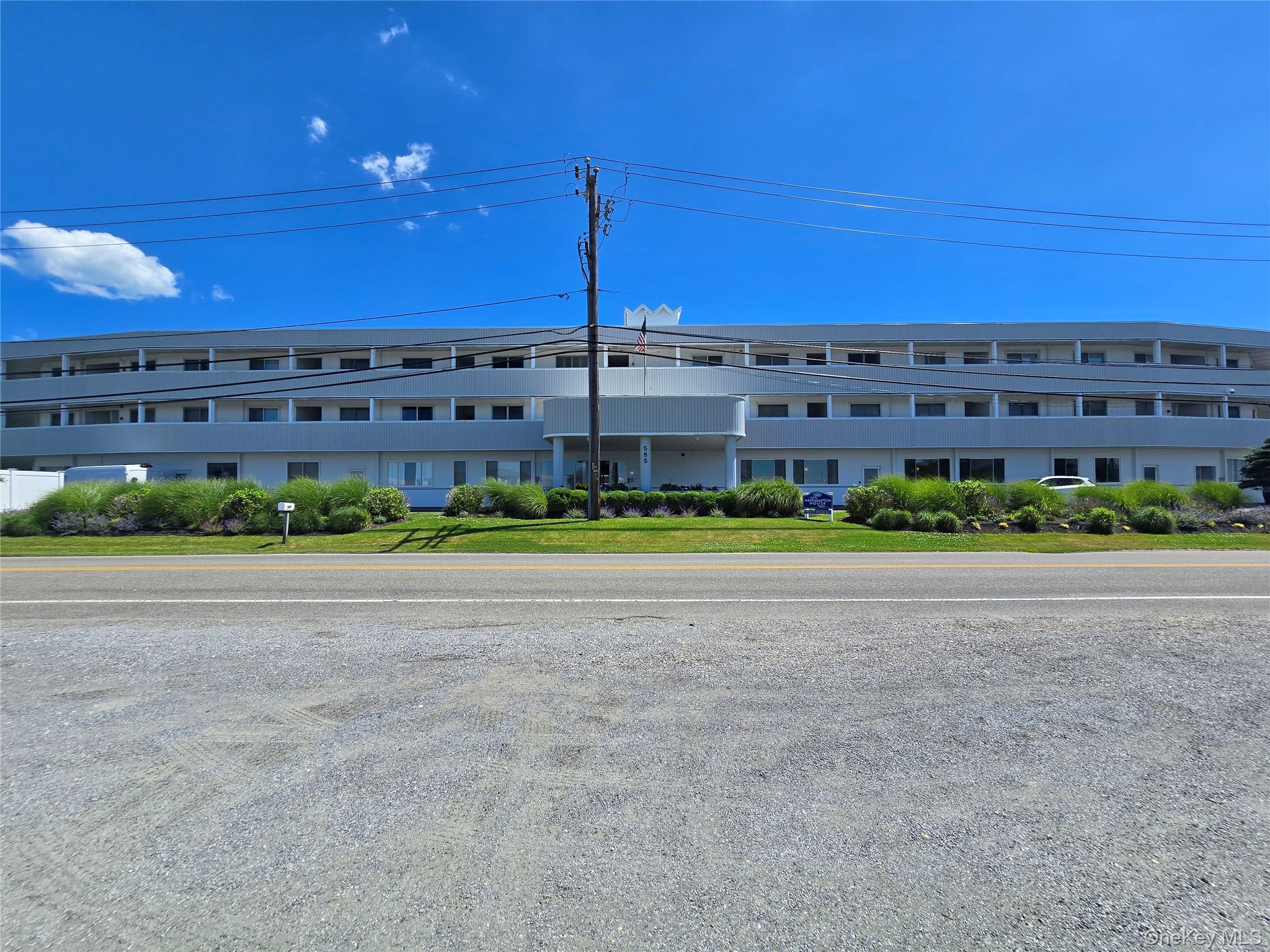585 Dune Road, Unit L10 Westhampton, NY 11978 - Photo 22 of 25 Multi-story structure with a light-colored exterior and multiple balconies