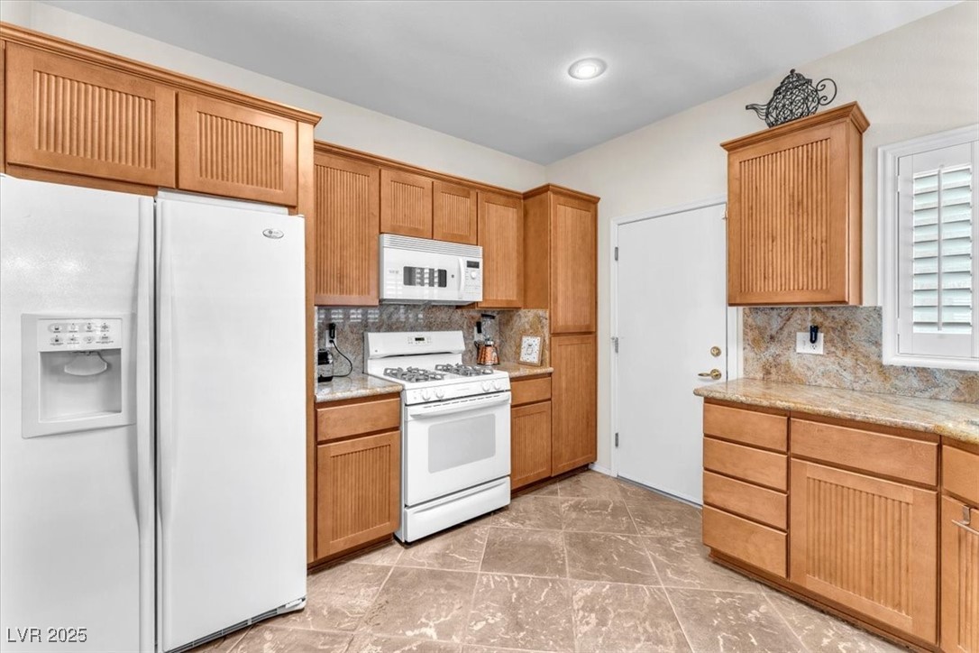 3056 Monroe Park Road Henderson, NV 89052 - Photo 5 of 28 Kitchen featuring tasteful backsplash and white appliances