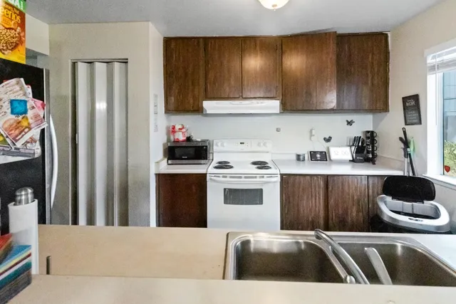a kitchen with stainless steel appliances granite countertop a refrigerator sink and stove