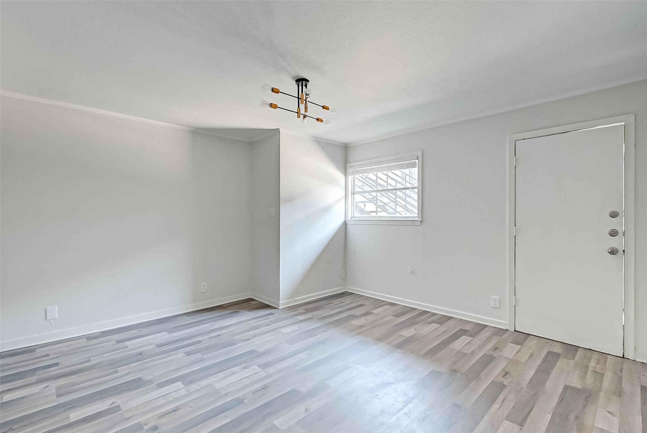 2420 McDuffie Street, Unit 1A Houston, TX 77019 - Photo 4 of 11 wooden floor in an empty room with a window