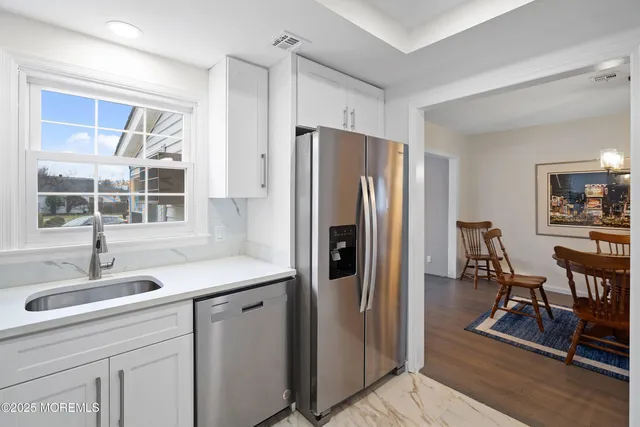 a kitchen with stainless steel appliances granite countertop a refrigerator and a sink