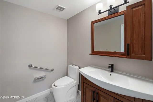 a bathroom with a toilet a sink and mirror