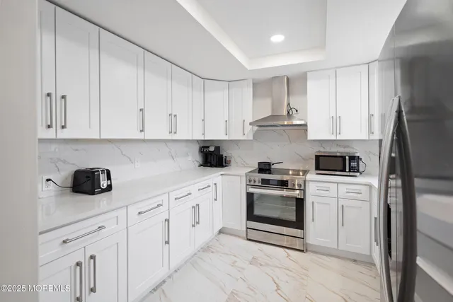a kitchen with white cabinets and appliances