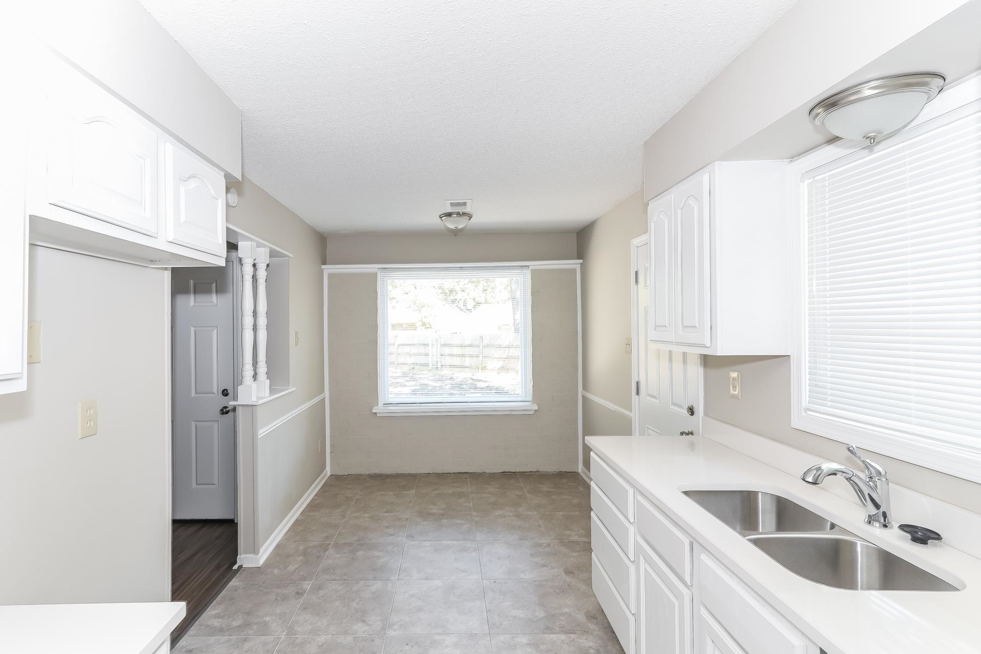 6076 Elk Grove Road Memphis, TN 38115 - Photo 5 of 15 a kitchen with a sink cabinets and window