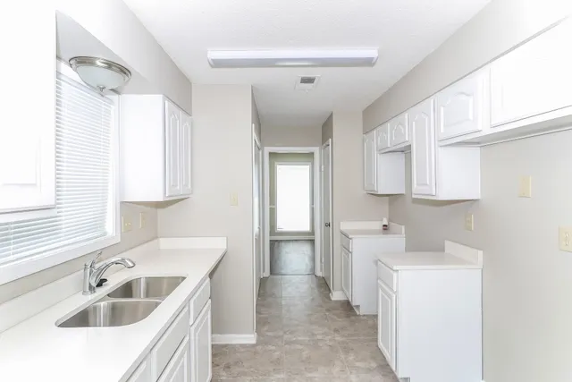 a kitchen with a sink cabinets and window