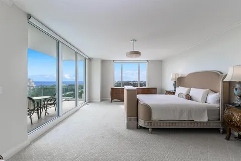 a bedroom with a bed and a large window with outer view