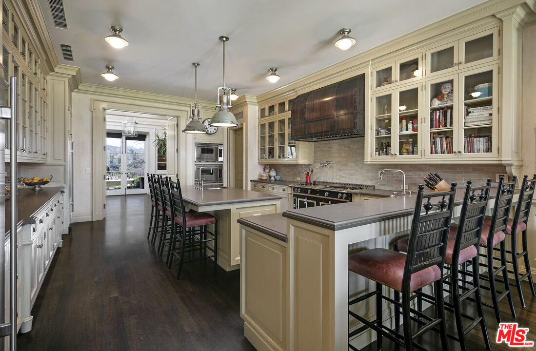 10702 Levico Way Los Angeles, CA 90077 - Photo 16 of 35 a kitchen with a table chairs stove and cabinets