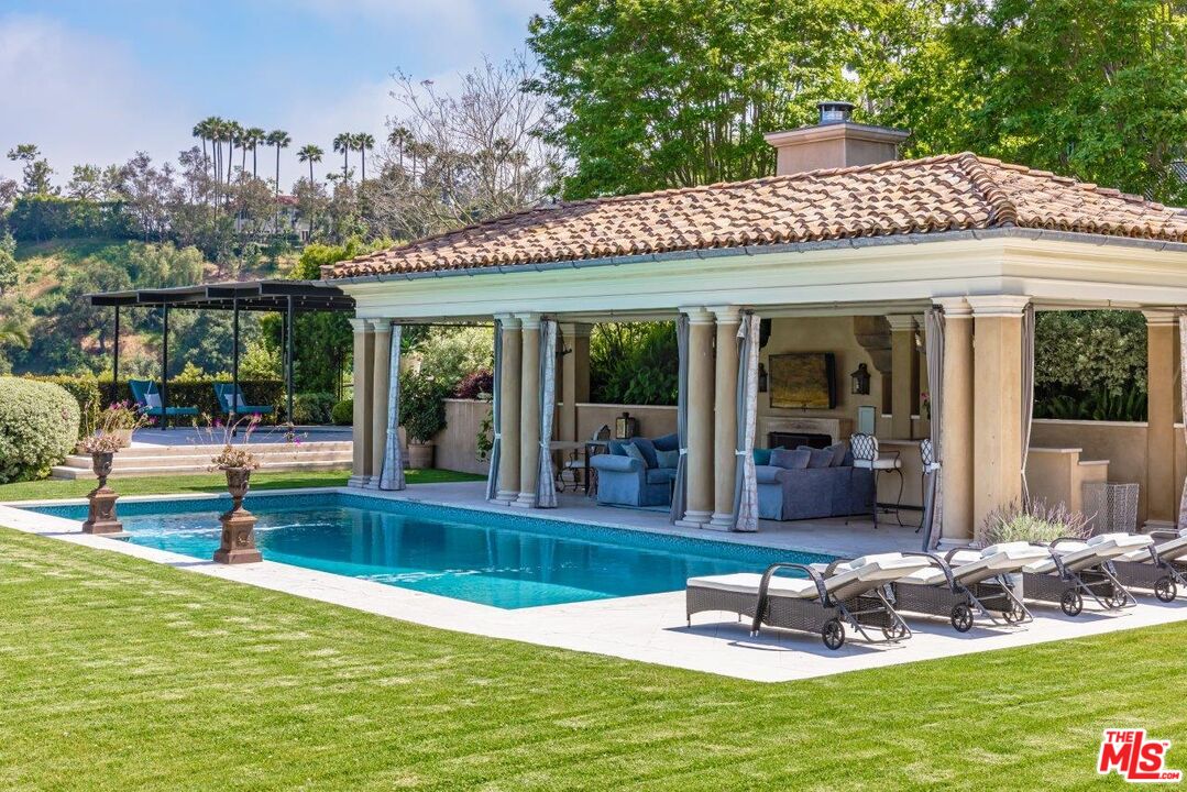 10702 Levico Way Los Angeles, CA 90077 - Photo 26 of 35 a view of a patio with a table chairs and floor to ceiling window