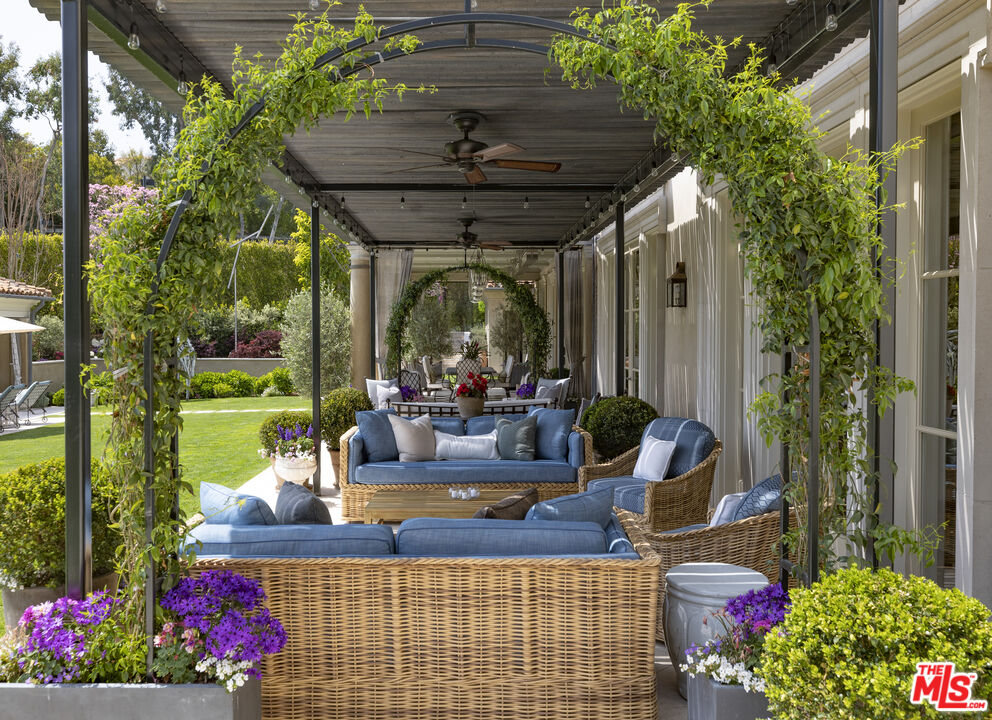 10702 Levico Way Los Angeles, CA 90077 - Photo 27 of 35 a view of a patio with table and chairs potted plants and large tree