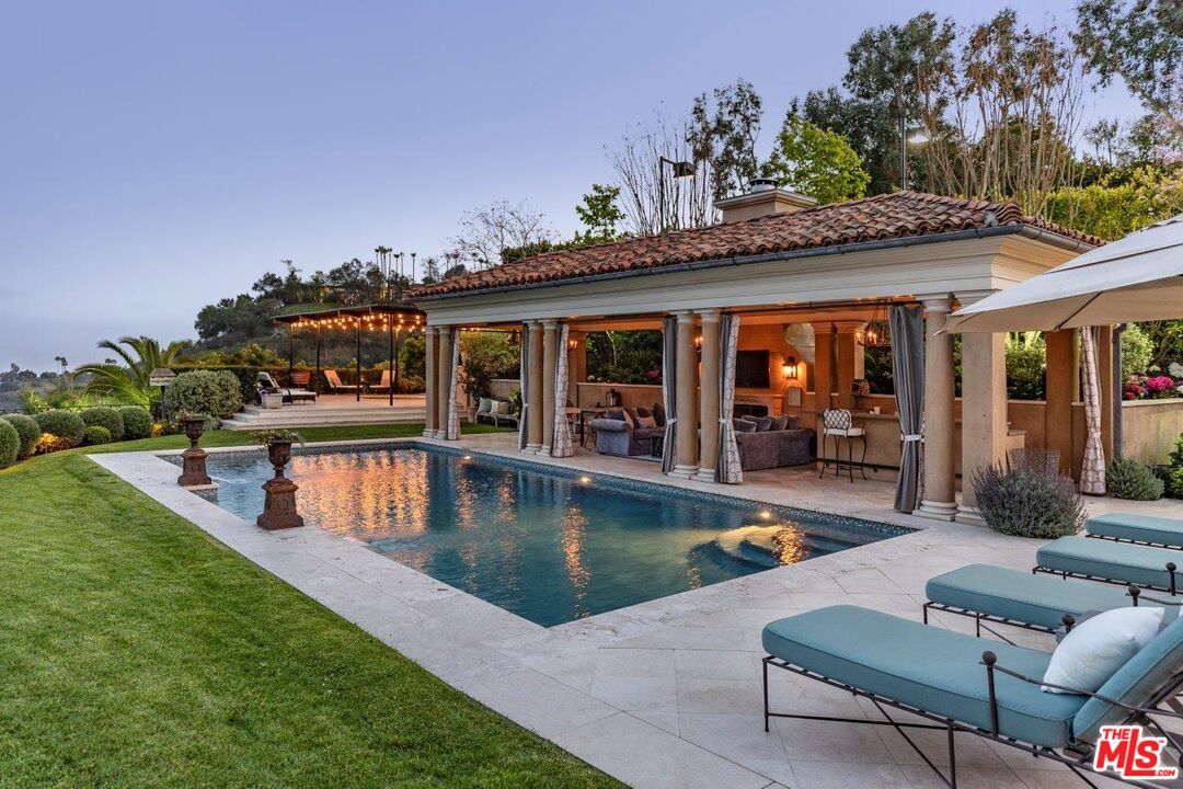 10702 Levico Way Los Angeles, CA 90077 - Photo 33 of 35 a view of a house and swimming pool with a couches chairs and a yard