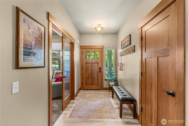 a view of a hallway with wooden floor and windows
