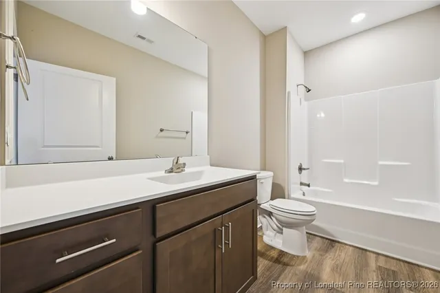 a bathroom with a sink a toilet a large mirror and shower