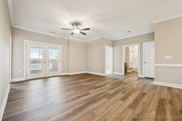 a view of an empty room with a window and wooden floor