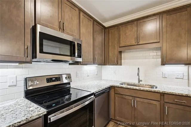 a kitchen with granite countertop a stove microwave and sink