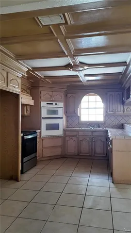 a kitchen with stainless steel appliances kitchen island granite countertop a refrigerator and a stove top oven