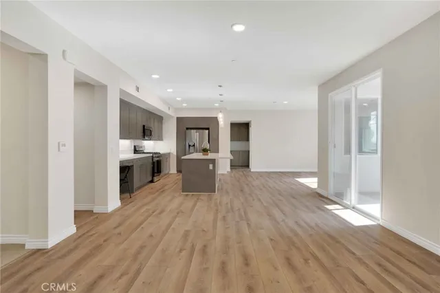 a large kitchen with cabinets wooden floor and stainless steel appliances