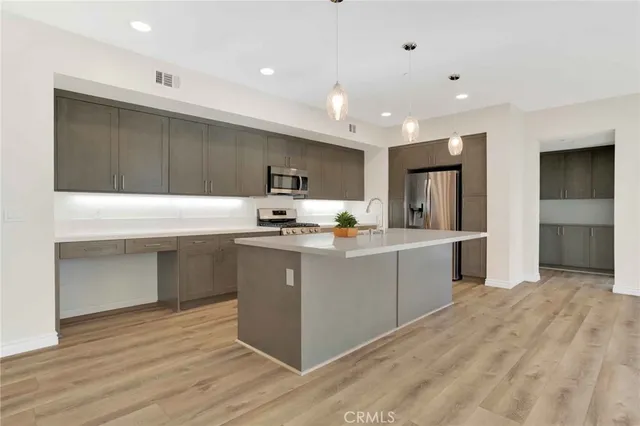 a kitchen with kitchen island granite countertop wooden cabinets a sink and a stove
