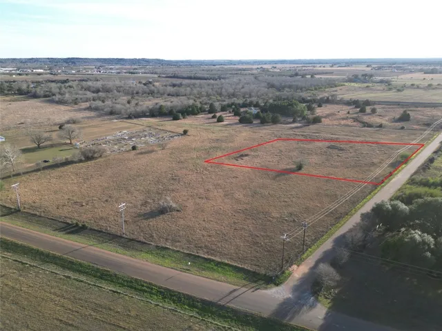 a view of a dry yard with wooden fence
