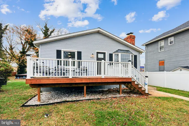 a view of a house with a wooden deck and a yard