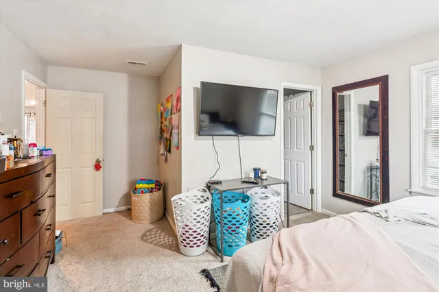 a bedroom with a bed a flat screen tv and a window