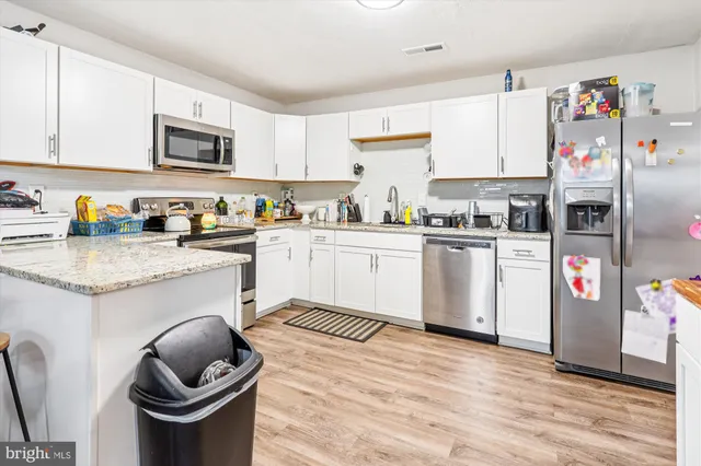 a kitchen with granite countertop a sink a stove and wooden cabinets