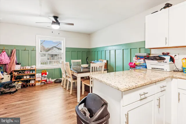 a kitchen with stainless steel appliances granite countertop a sink dishwasher and a dining table with wooden floor