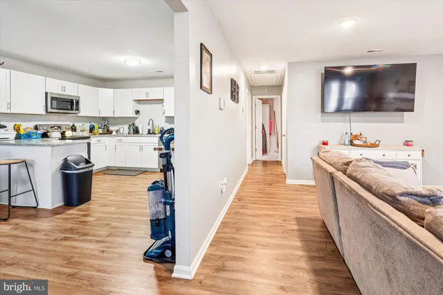 a kitchen with stainless steel appliances wooden floor and sink