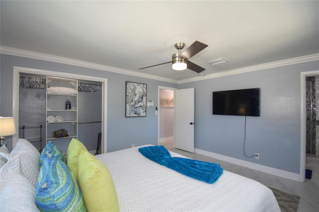 214 Southeast 5th Street Dania Beach, FL 33004 - Photo 30 of 50 a bedroom with a bed a mirror and a flat screen tv