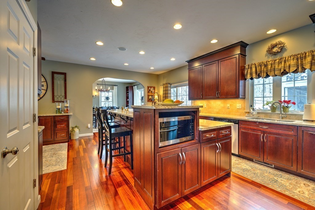 59 Lake Road Brookfield, MA 01506 - Photo 6 of 42 a kitchen with stainless steel appliances granite countertop a refrigerator a stove top oven and a dining table with wooden floor
