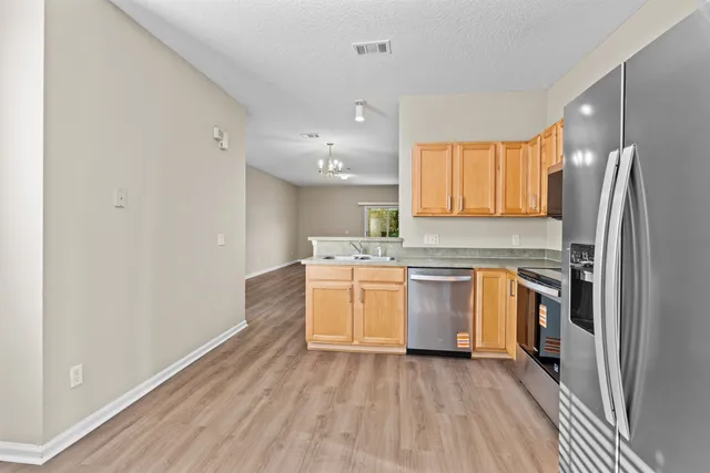 a kitchen with a refrigerator sink and stove top oven