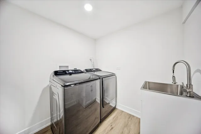 a utility room with sink dryer and washer