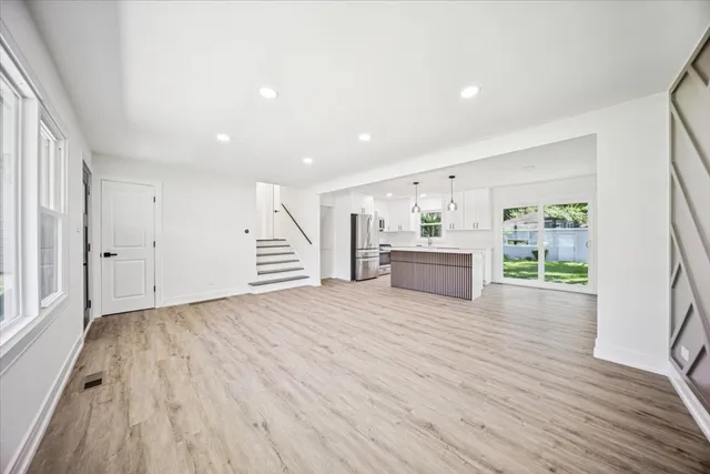 a view of a kitchen with wooden floor and stairs