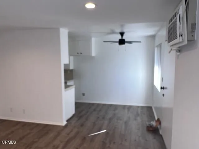 an empty room with a ceiling fan and windows