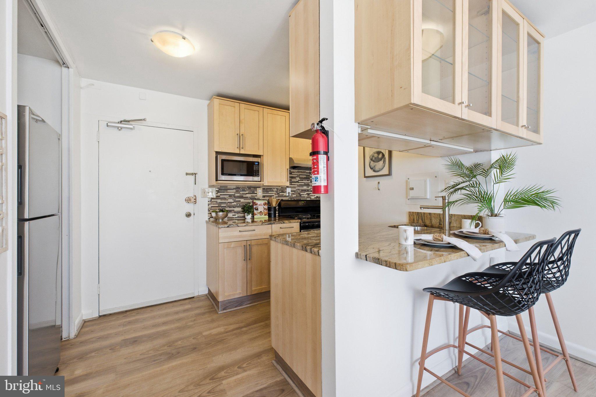 522 21st Street Northwest, Unit 407 Washington, DC 20006 - Photo 8 of 17 a kitchen with stainless steel appliances kitchen island granite countertop a refrigerator and microwave