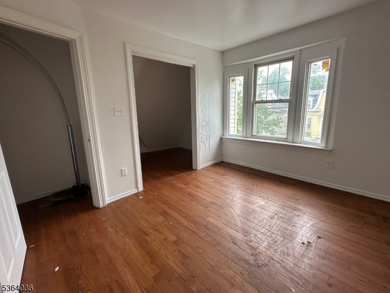 348 13th Avenue, Unit 3 Newark, NJ 07103 - Photo 14 of 14 an empty room with wooden floor and windows