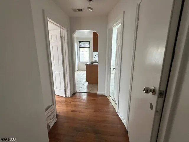a view of a hallway with wooden floor and closet