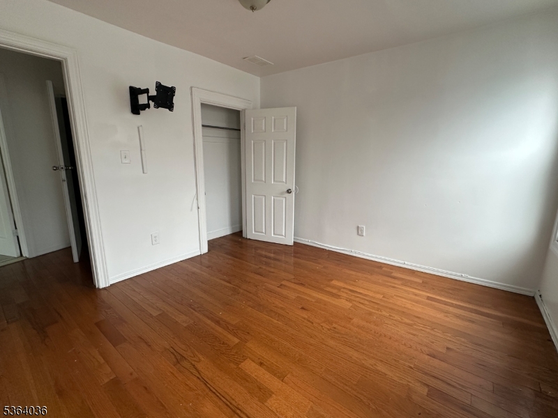 348 13th Avenue, Unit 3 Newark, NJ 07103 - Photo 9 of 14 an empty room with wooden floor and closet