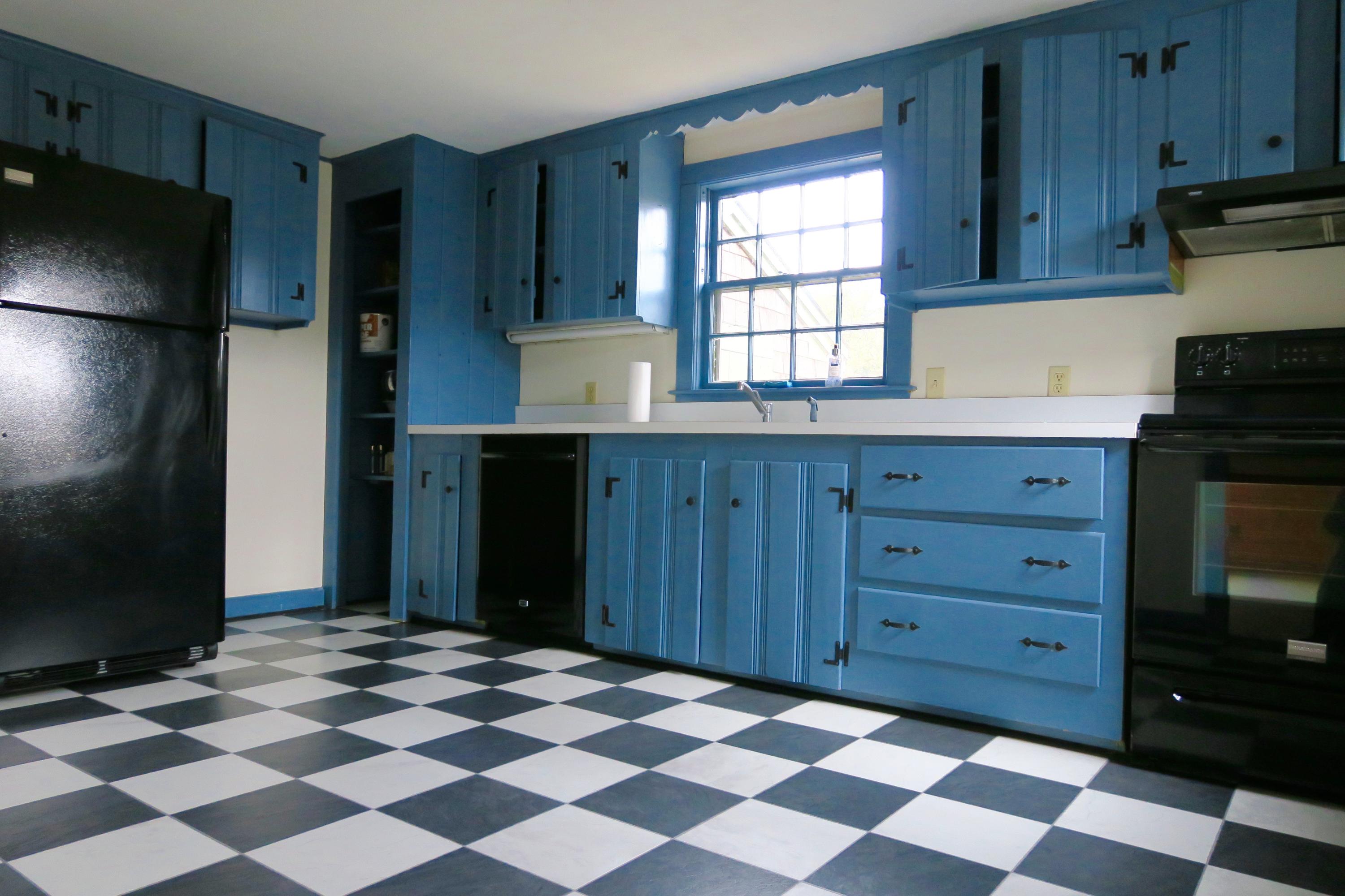 58 Surfside Road West Dennis, MA 02670 - Photo 19 of 31 a kitchen with a black white checkered floor and cabinets