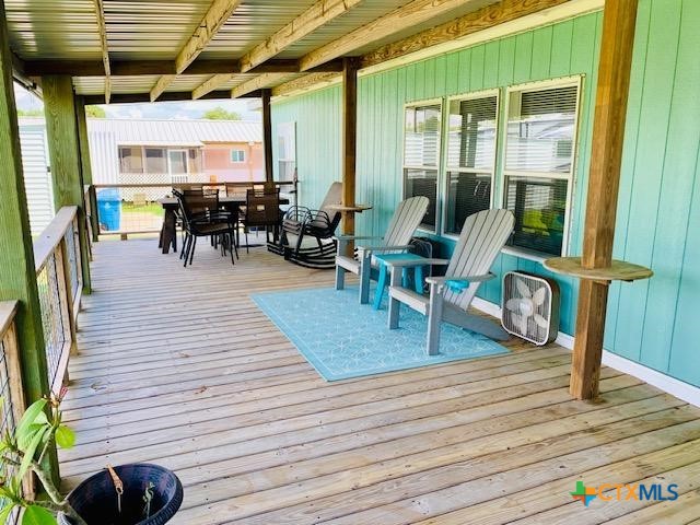 77 Blue Street Port O'Connor, TX 77982 - Photo 5 of 27 a view of a deck with table and chairs with wooden floor and plants