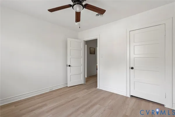 a view of an empty room with closet and a window