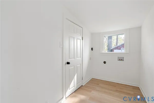 a view of a big room with wooden floor and windows