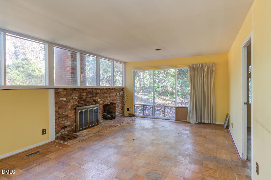 806 Kings Mill Road Chapel Hill, NC 27517 - Photo 7 of 45 a view of an empty room with a fireplace and a window