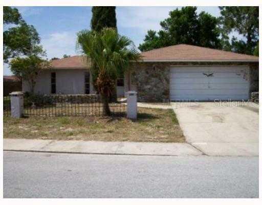 6445 Juniper Road Port Richey, FL 34668 - Photo 1 of 1 a backyard of a house with table and chairs