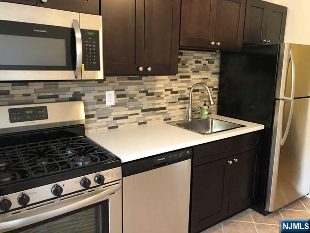 2205 North Central Road, Unit 5A Fort Lee, NJ 07024 - Photo 13 of 24 a kitchen with sink a stove and cabinets