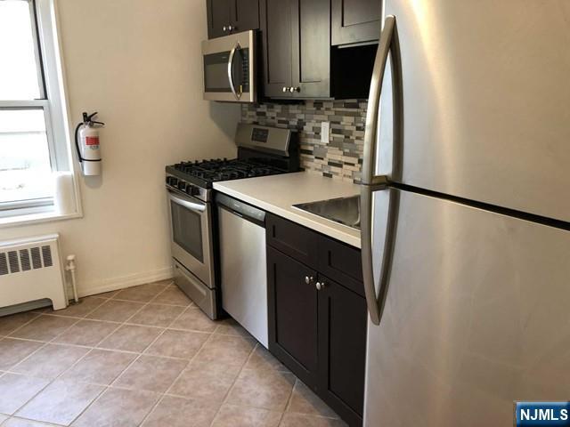2205 North Central Road, Unit 5A Fort Lee, NJ 07024 - Photo 14 of 24 a kitchen with stainless steel appliances a refrigerator and a sink