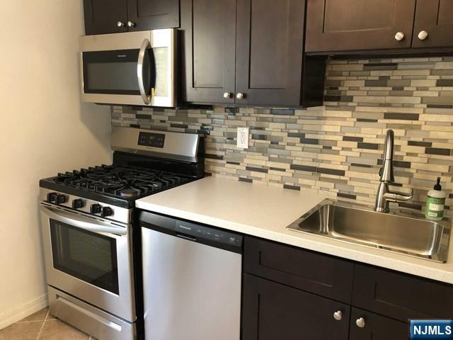 2205 North Central Road, Unit 5A Fort Lee, NJ 07024 - Photo 15 of 24 a kitchen with a sink stove and microwave